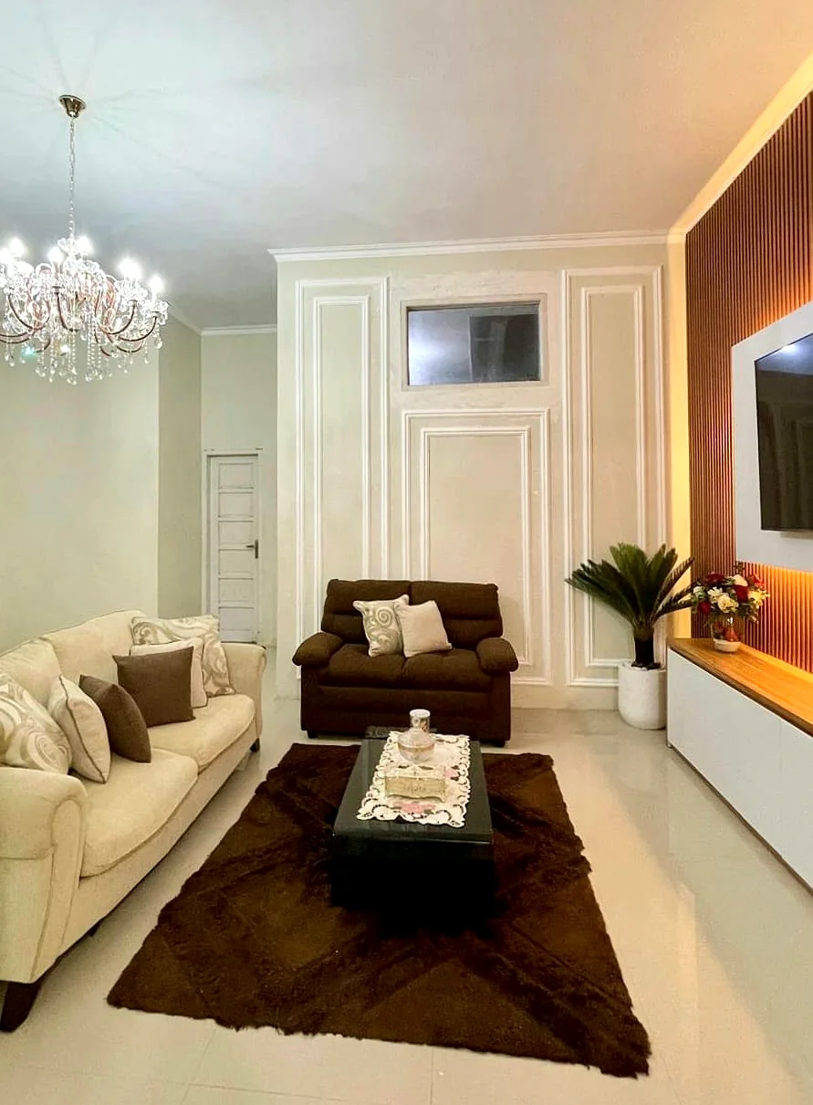 Home Interior ruang tamu dengan wall moulding dan pencahayaan hangat karya Phinisi Interior