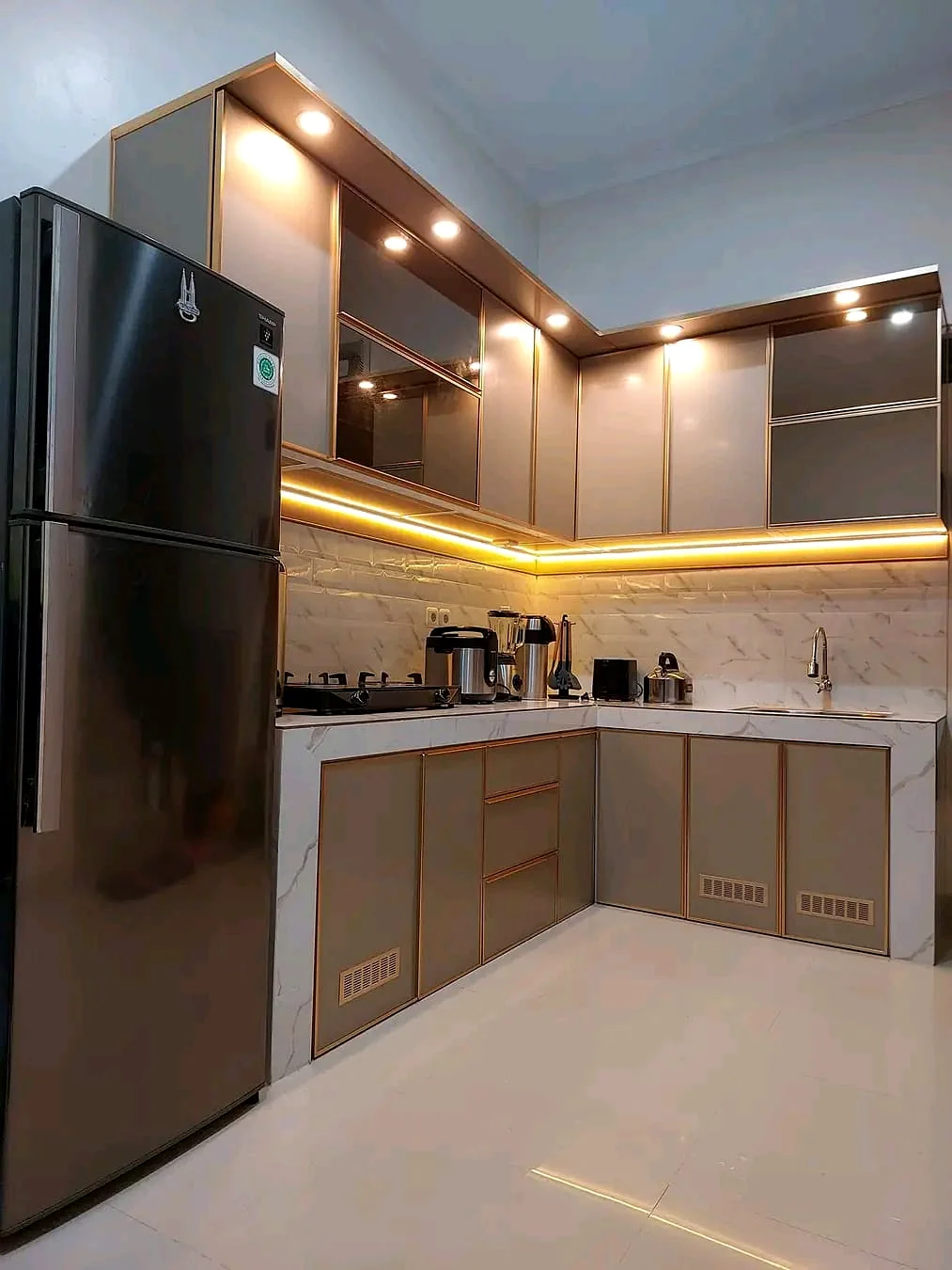 Kitchen set modern abu dengan aksen pencahayaan hangat