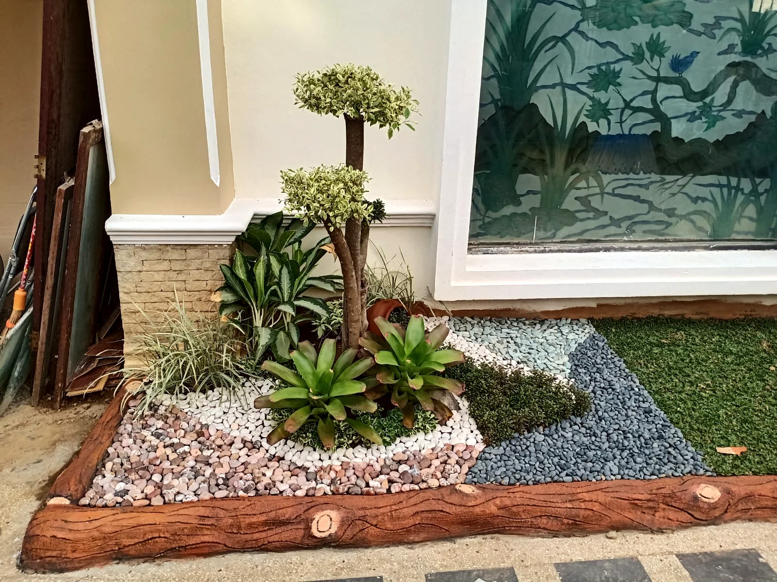 Taman minimalis di sisi rumah dengan batu dekoratif